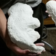 A person holds casts of giant sloth footprints